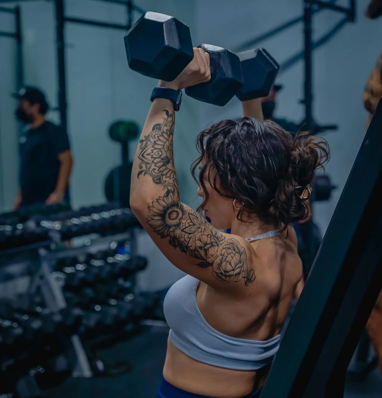 Woman lifting weights, thriving — peptide optimization at Xena Health